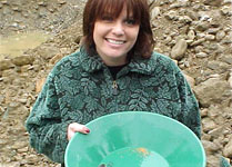 Girl gold panning showing gold in pan