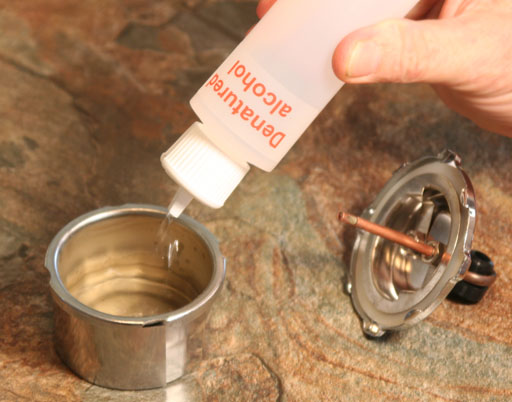 Squirting in denatured alcohol into metal can of alcohol burner