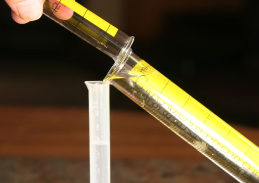 Pour pieces of the mineral into grad cylinder