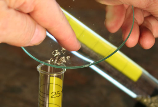 Rake small pieces of mineral into 25 mL cylinder
