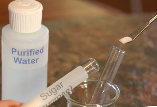 Placing sugar into test tube. 