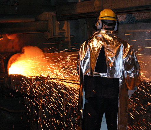 molten metal coming out of a furnace towards a guy