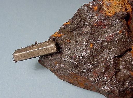 a magnet attracted to a specimen of magnetite mineral