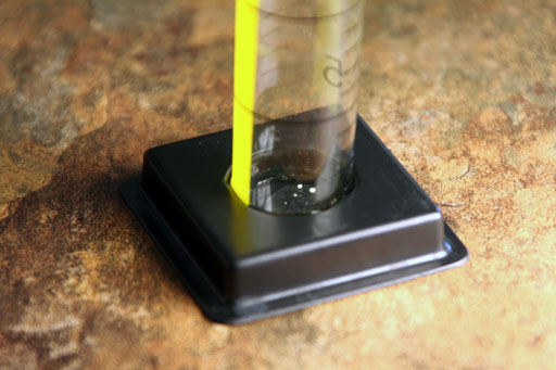 grains of iron sulfate at bottom of graduated cylinder