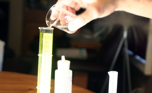 pour copper solution from beaker into 100 mL grad cylinder