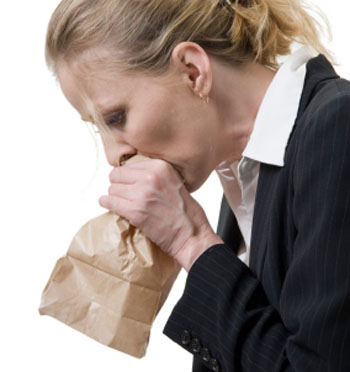 woman breathing into paper bag