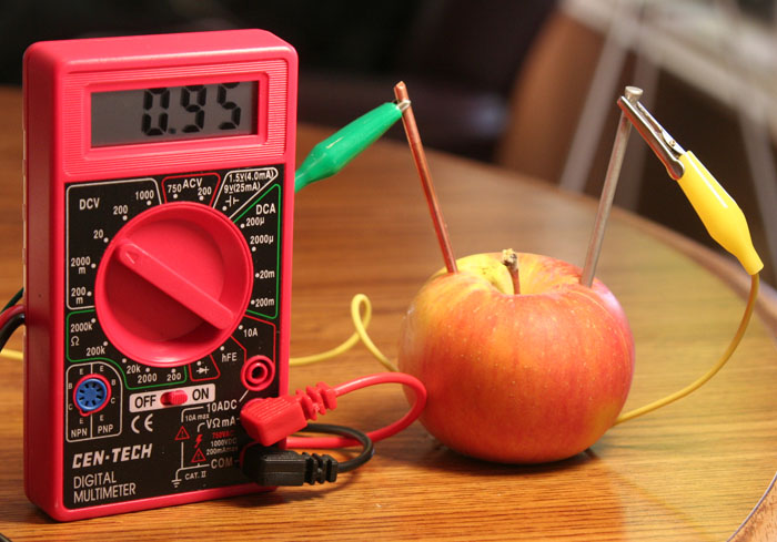 Apple with zinc nail hooked to multimeter