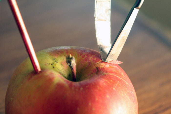 Push aluminum strip into apple